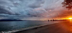 Sonnenuntergang am Wasser mit dunklen Wolken und hellem Abendlicht